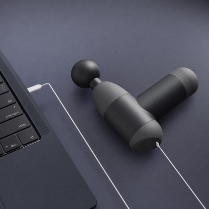 MyoPulse Mini en charge via son câble USB-C, posé à côté d'un ordinateur portable